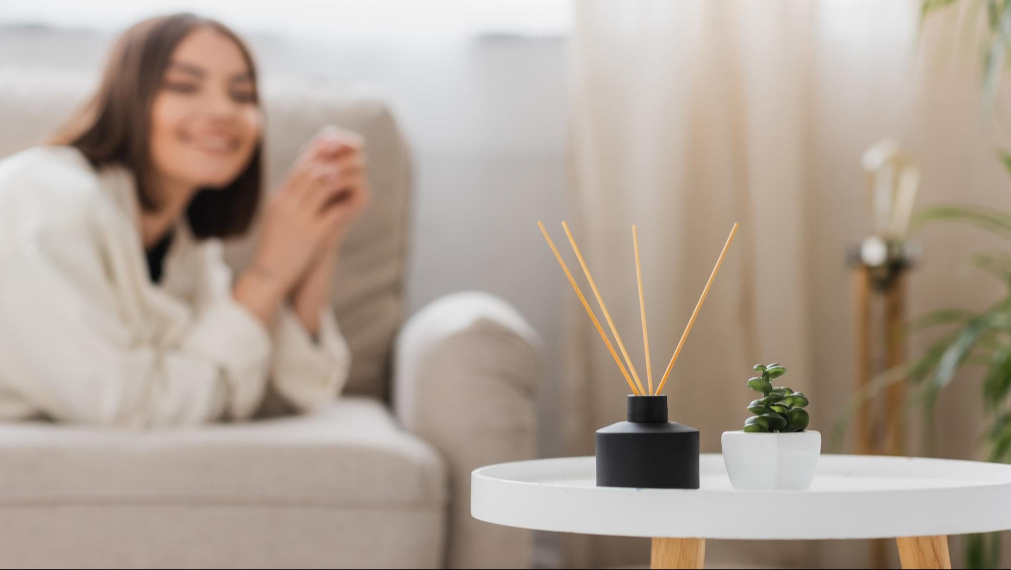 Woman sitting on a couch with a blurred background of a living room.
